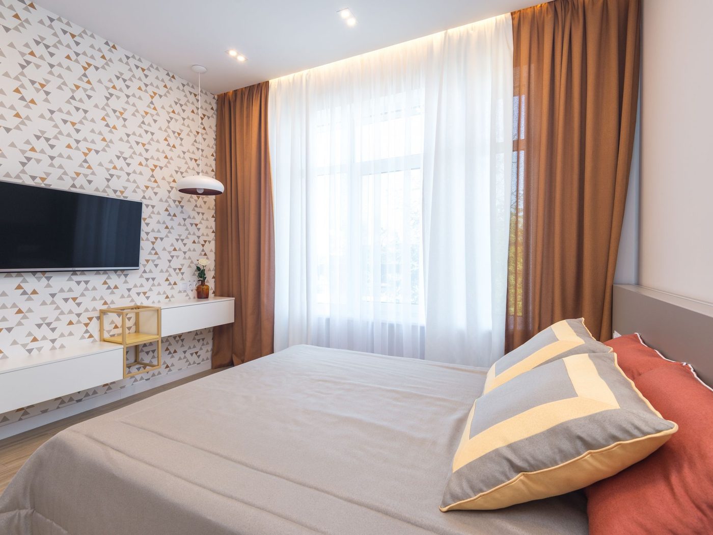 Warm neutral bedroom with a delicate small-pattern wallpaper and soft daylight