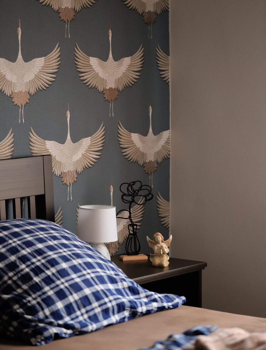 Bedroom with a slate-blue feature wall of large white crane prints