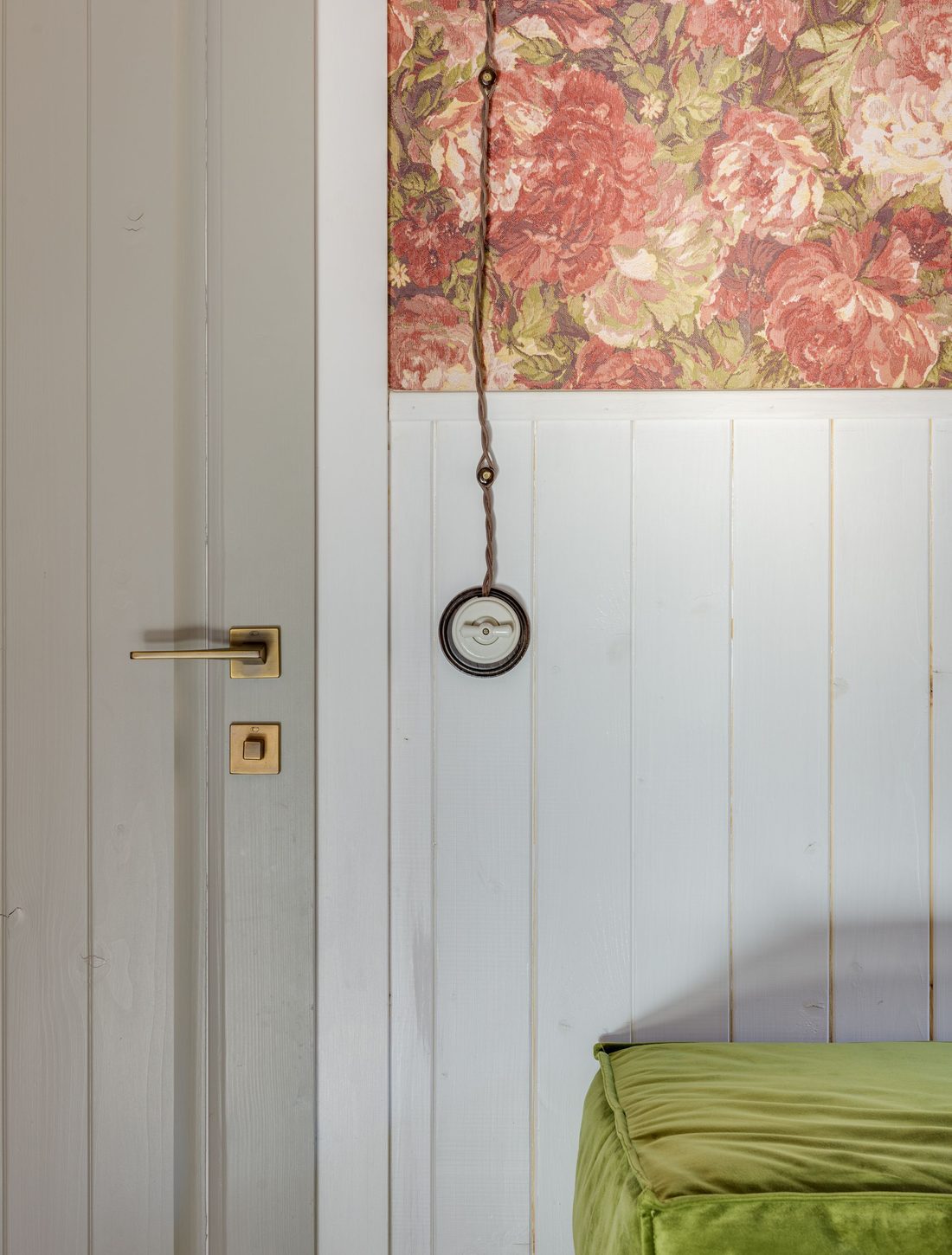 Bold red floral wallpaper panel set above white paneling