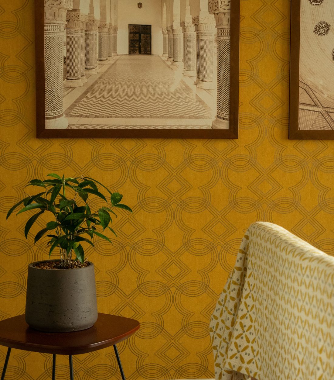 Warm room with a golden-yellow geometric patterned wall and framed art